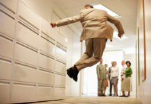 Senior Businessman Jumping in Corridor