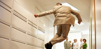 Senior Businessman Jumping in Corridor