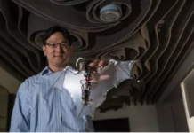 Soon-Jo Chung, associate professor of aerospace and Bren Scholar at Caltech, holds the Bat Bot.